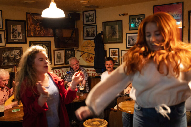Vier mensen die muziek maken en dansen in een ierse pub. 