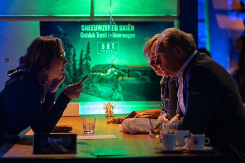 Collega Lian geeft uitleg aan klanten tijdens een informatieavond over Scandinavian Mountains wintersport