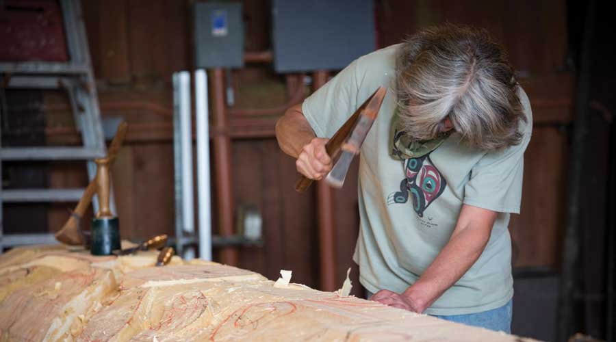 In Sitka toont een totembouwer zijn handarbeid In Sitka toont een totembouwer zijn handarbeid