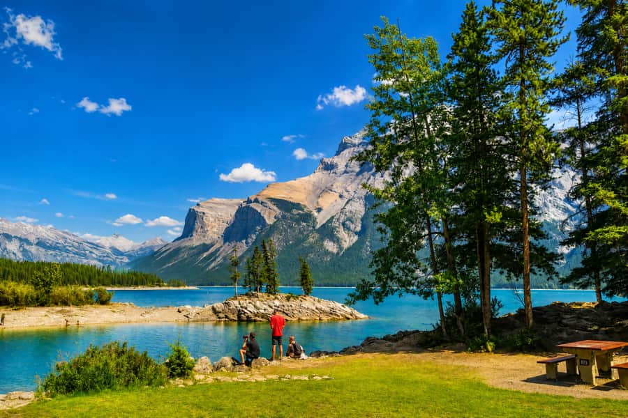 Reizigers bij een meer in de Rocky Mountains tijdens een groepsreis door Canada