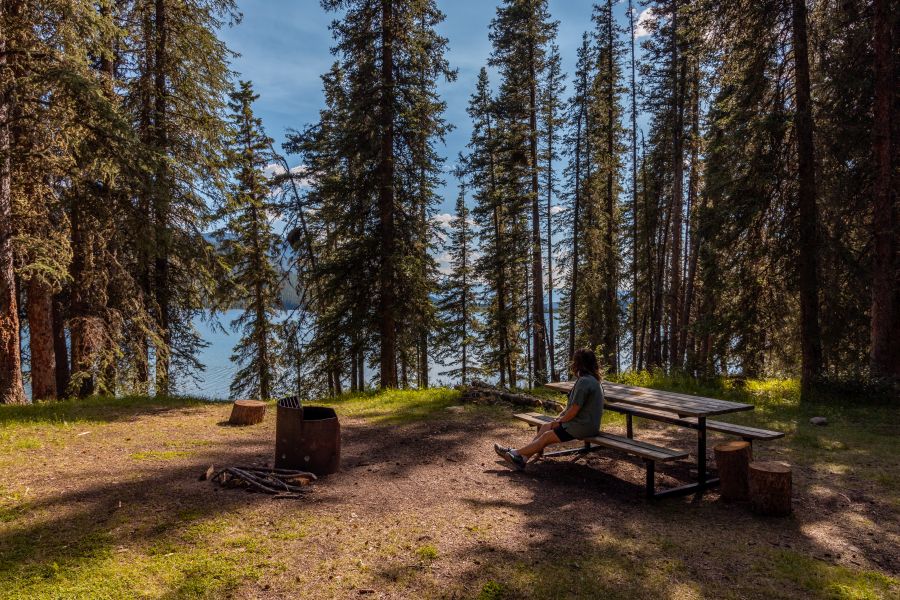 Siting at a picnic table at a campsite in Rock Lake Provincial Recreation Area