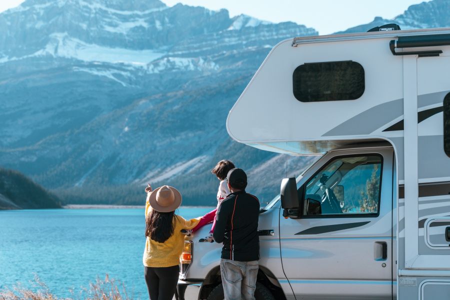 Familie staat naast een Fraserway camper met uitzicht op de bergen in West-Canada