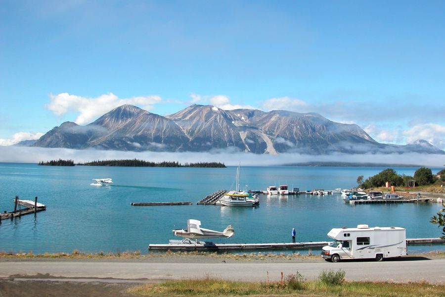 Camper van Fraserway langs het water met bergen op de achtergrond in Noord-Canada.