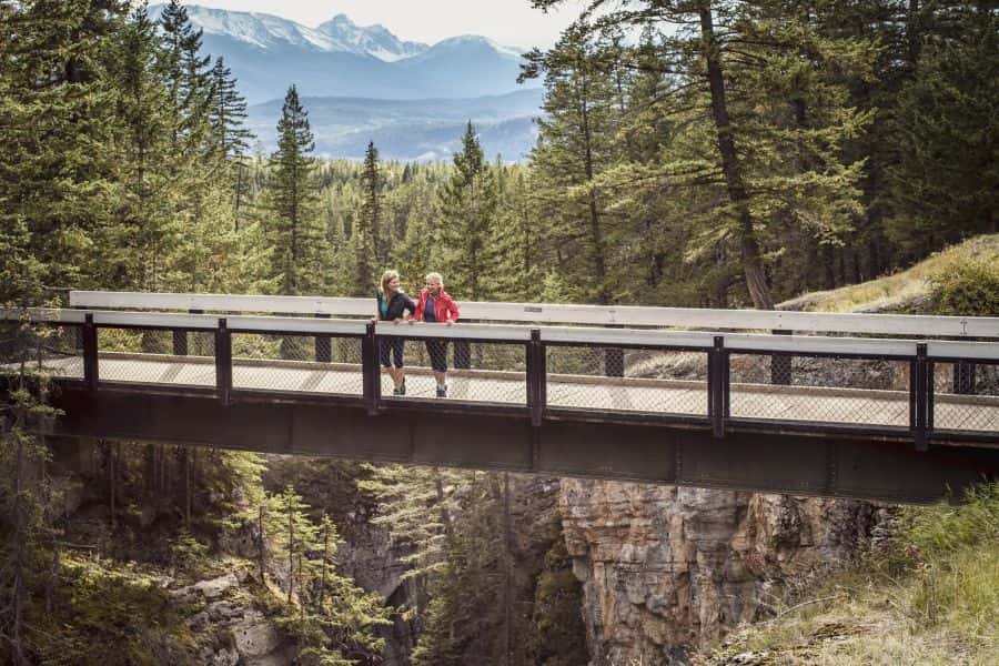 Wandelaars op een brug boven Maligne Canyon in Alberta in Canada.