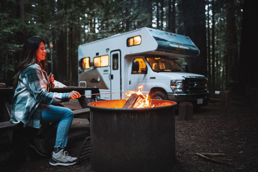 Camper van Cruise Canada naast een vuurton in het bos in Canada.