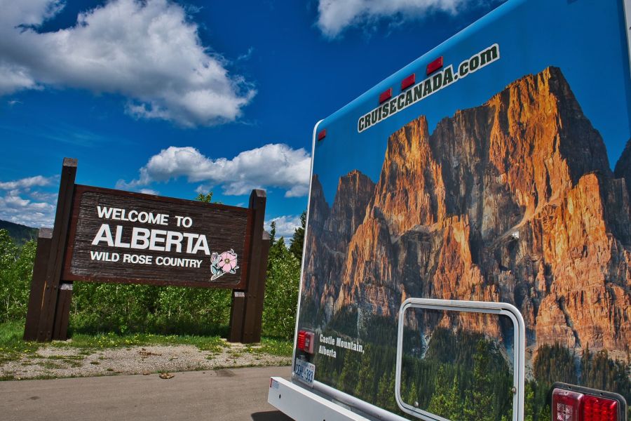 Camper van Cruise Canada naast het welkomstbord van de provincie Alberta in Canada.