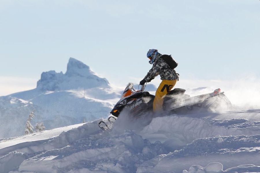 Man op sneeuwscooter in de sneeuw in Whistler in Canada.