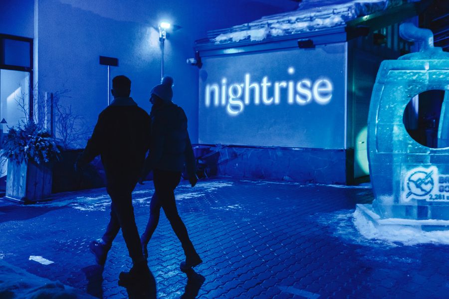 Mensen lopen langs licht installaties van Nightrise bij de Banff Gondola in Canada.