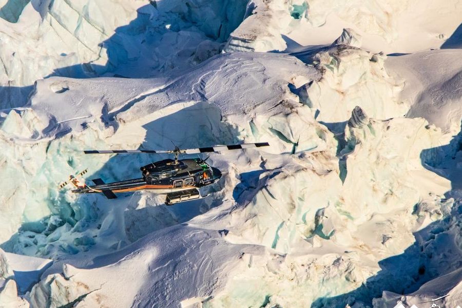 Helikopter boven bergtoppen tijdens een heli-ski excursie in de Rockies in Canada