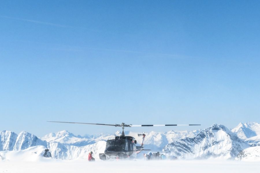 Helikopter staat op top van berg tijdens heli-ski excursie in de Rocky Mountains in Canada