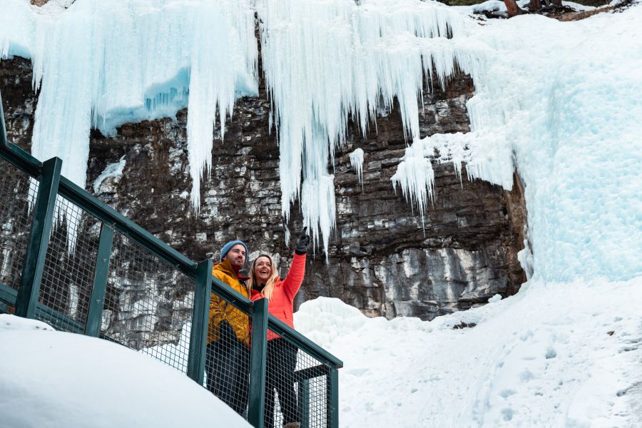 Stel op de loopbrug bij Johnston Canyon in Banff tijdens een ijswandel excursie
