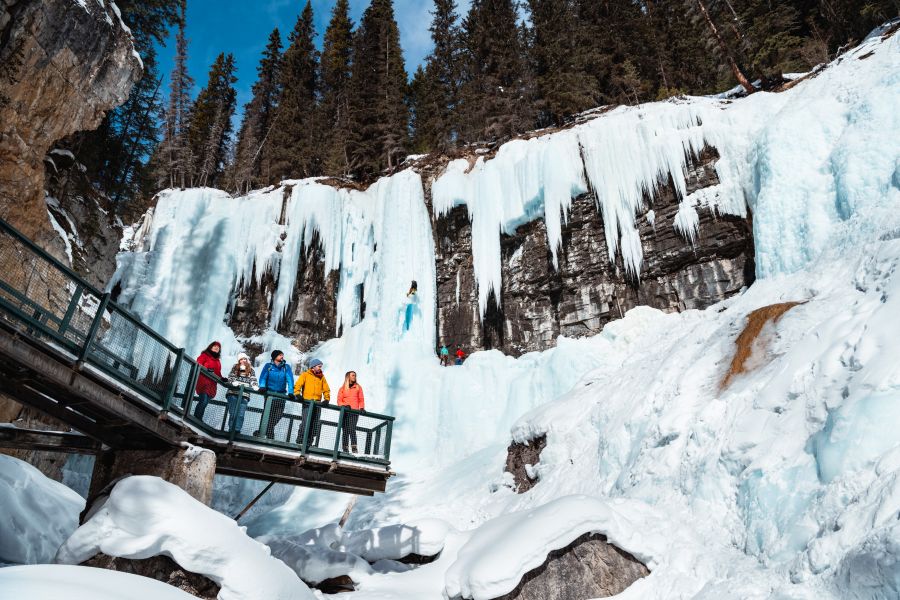 Wandelaars staan op loopbrug in Johnston Canyon tijdens ijswandel excursie in Canada