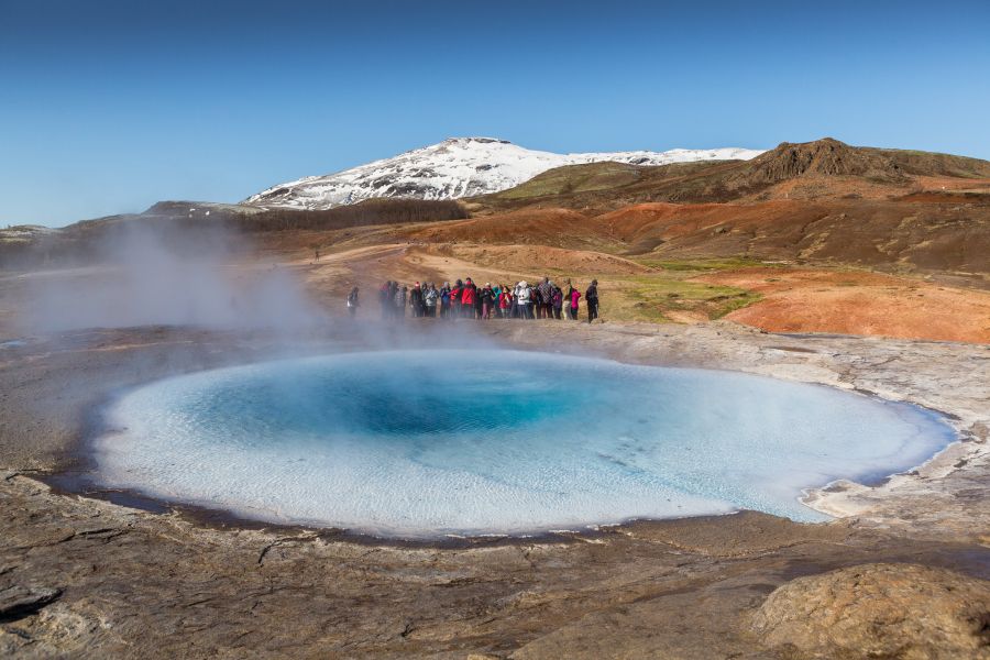 Mensen staan bij Geysir in IJsland tijdens een reis in de herfst