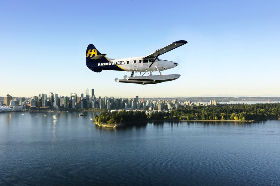 Watervliegtuig boven water met Vancouver in de verte in British Columbia in Canada.