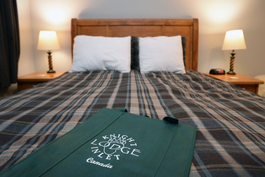 Opgemaakt bed in kamer bij Knight Inlet Lodge in British Columbia in Canada.