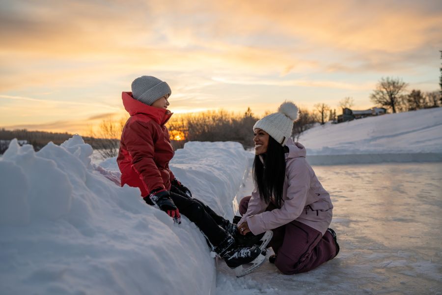 Vrouw en kind schaatsen bij Métis Crossing tijdens een winterreis naar Canada
