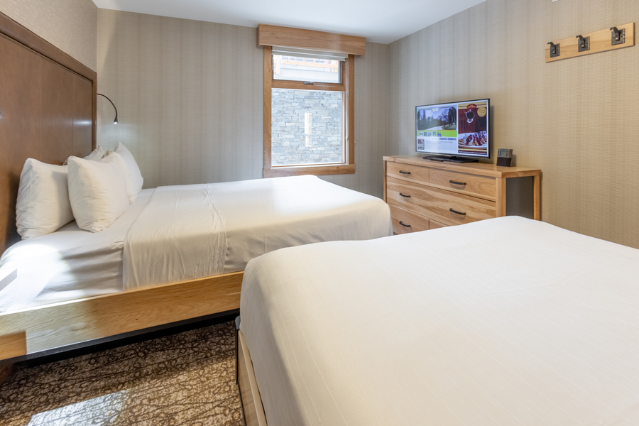 Slaapkamer met 2 queens in een superior suite met aparte slaapkamer bij Moose Hotel & Suites in Banff tijdens een wintersportreis naar Canada