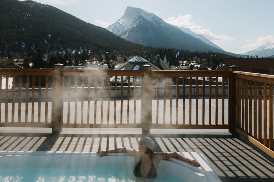Vrouw in de hot tub van Basecamp Suites in Banff tijdens een wintersportreis naar Canada