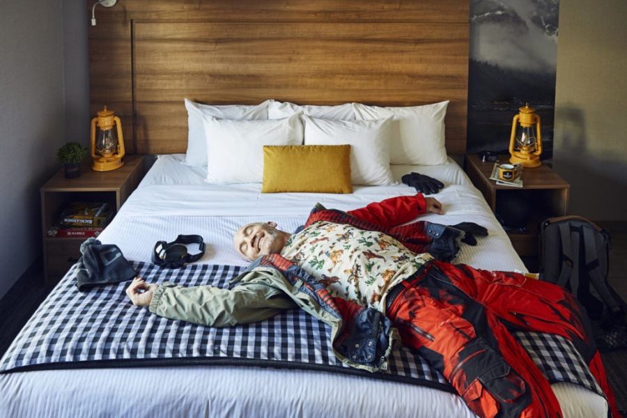 Hotel gast ligt op bed in Canalta Lodge in Banff tijdens een wintersportreis naar Canada