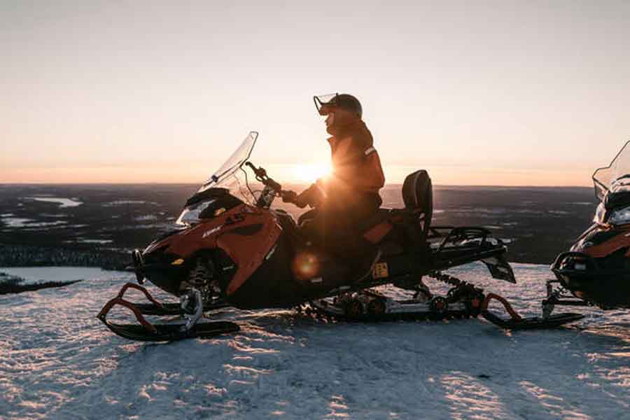 Sneeuwscooter in avondzon Levi