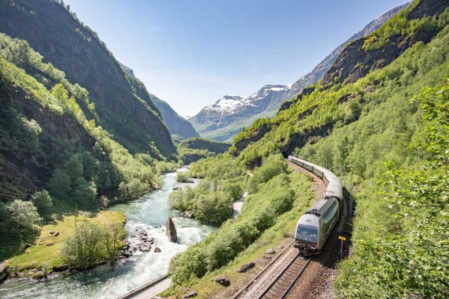 Excursies in Noorwegen - De Fl&aring;msbana trein naast een riviertje in de Fl&aring;mvallei. 