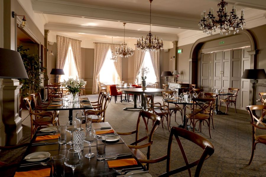 Het restaurant van Causeway Hotel in Bushmills met houten stoelen en gedekte tafels