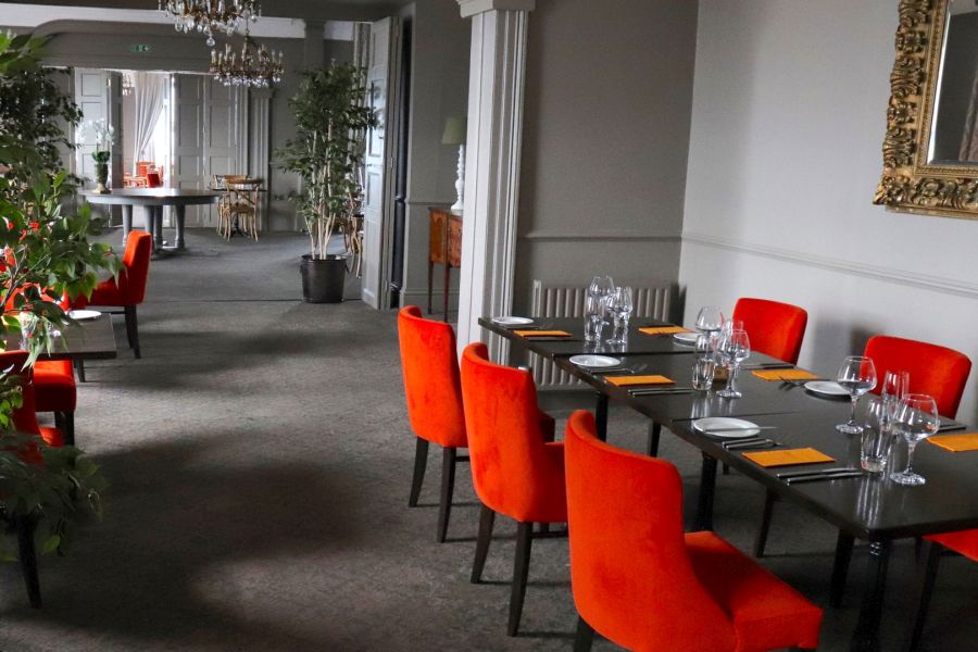 Het restaurant van het Causeway Hotel in Bushmills met rode stoelen aan een gedekte tafel