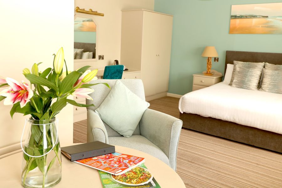 Een tweepersoonsbed met een zithoek in het Causeway Hotel in Bushmills