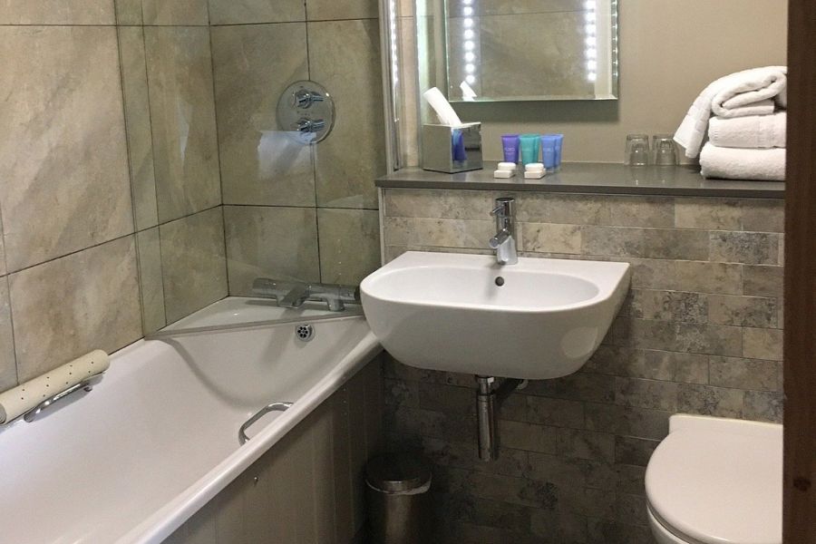 Een badkamer in het Causeway Hotel in Bushmills met uitzicht op de wastafel, douche en het toilet
