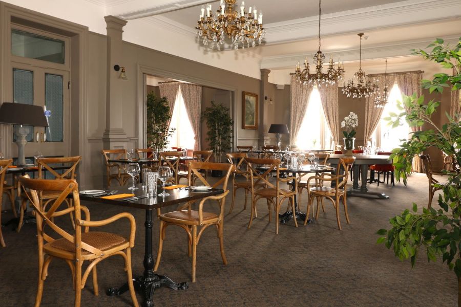 Het restaurant van het Causeway Hotel in Bushmills met allemaal gedekte tafels en kroonluchters