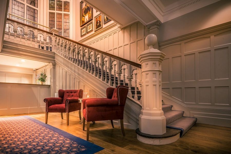 De trap in de hal in het Bishop`s Gate Hotel in Derry met een zithoekje beneden