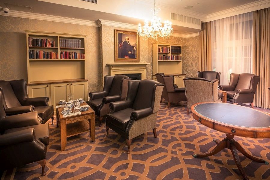 De lounge met twee zithoeken bij de openhaard in het Bishop`s Gate Hotel in Derry