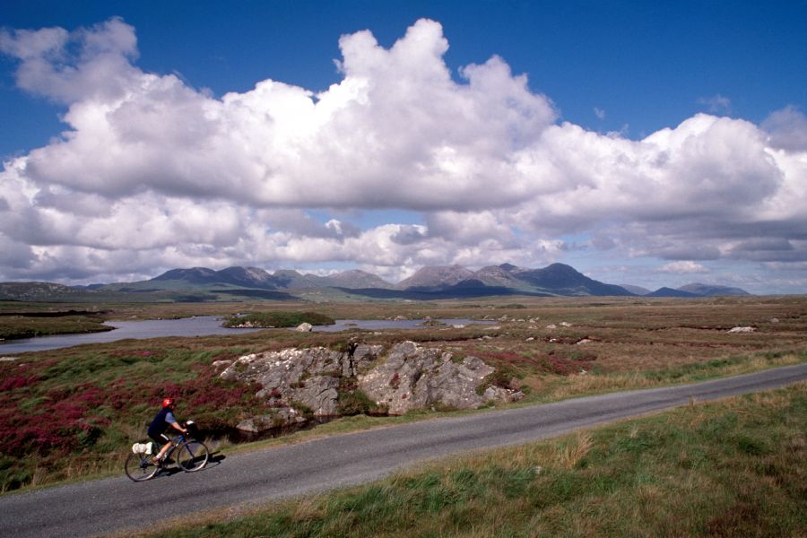 Een fietser met een rode helm fietsend door de Connemara vlakte