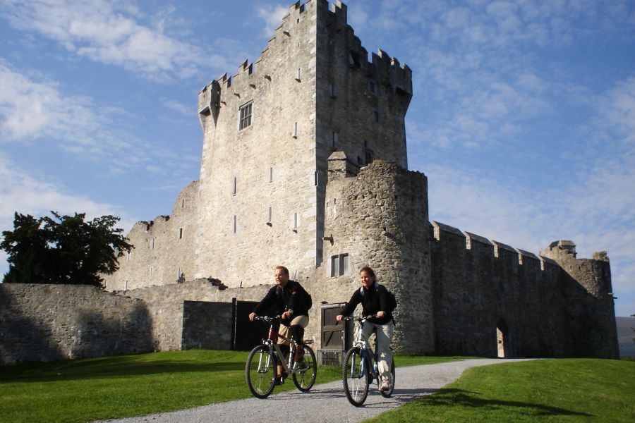 Twee fietsers fietsen langs Rosst Castle in Killarney