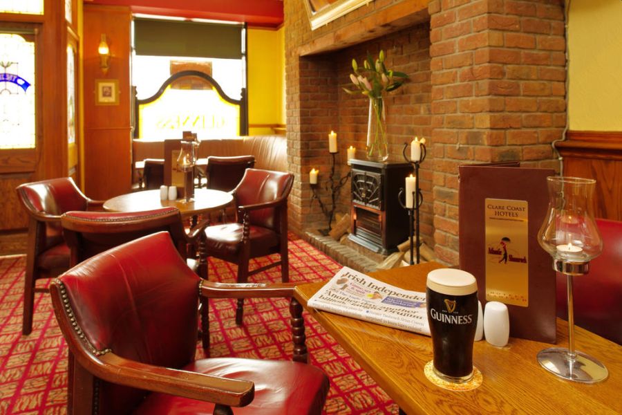 Een gedekte tafel waar een Guinness biertje klaar staat en er ligt en krant op de tafel