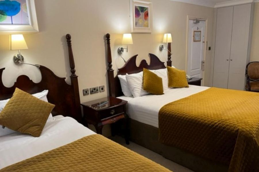 Een driepersoonskamer in het Atlantic Hotel Lahinch met een geel dekbed