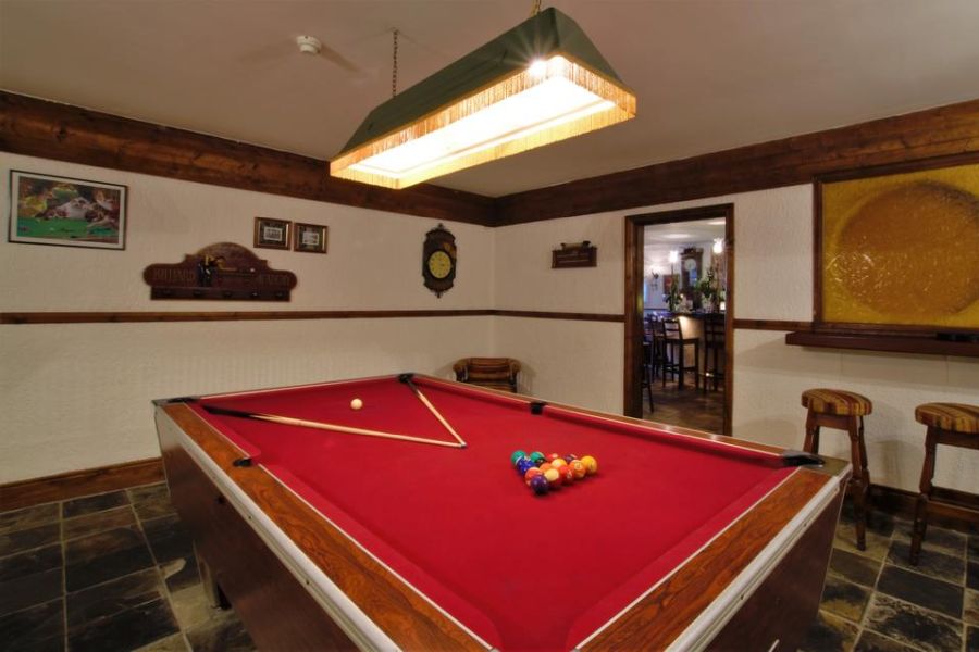 Een rode pooltafel waar de ballen al klaar liggen om te spelen in het Ardagh Hotel Clifden