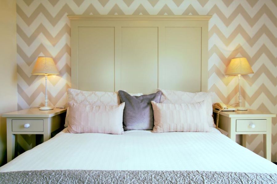 Een opgemaakt tweepersoonsbed met twee nachtkastjes naast het bed in het Ardagh Hotel Clifden