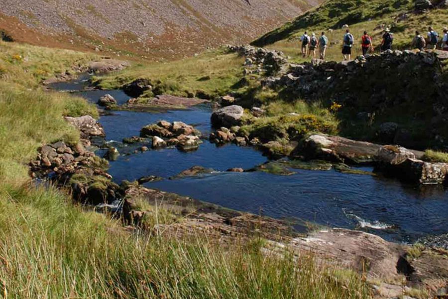 Een groep wandelaars die langs wandelt bij de rivier