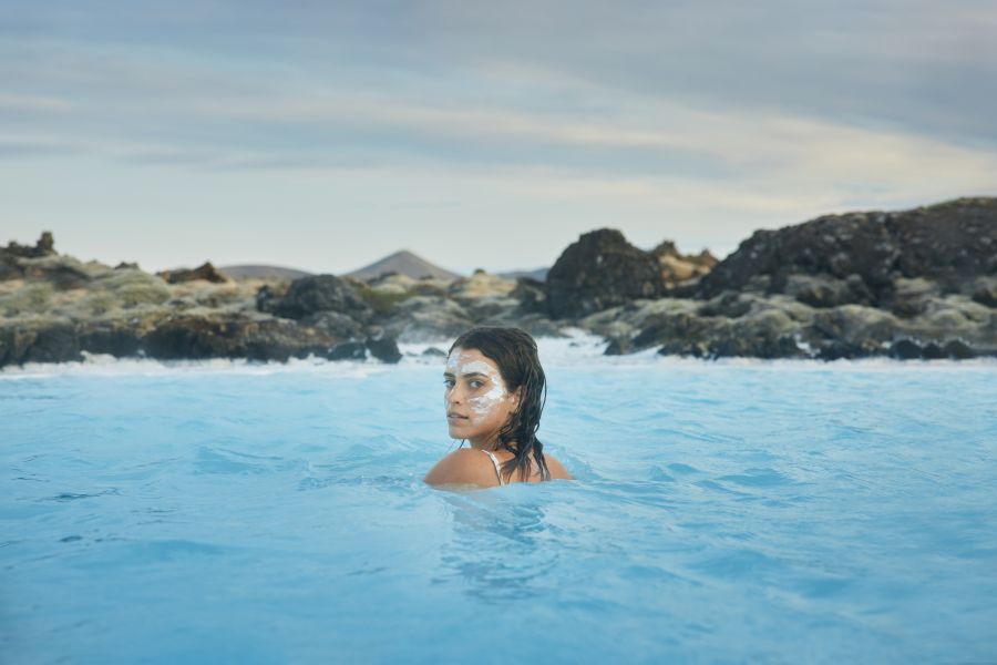 Vrouw zwemt in de Blue Lagoon in IJsland