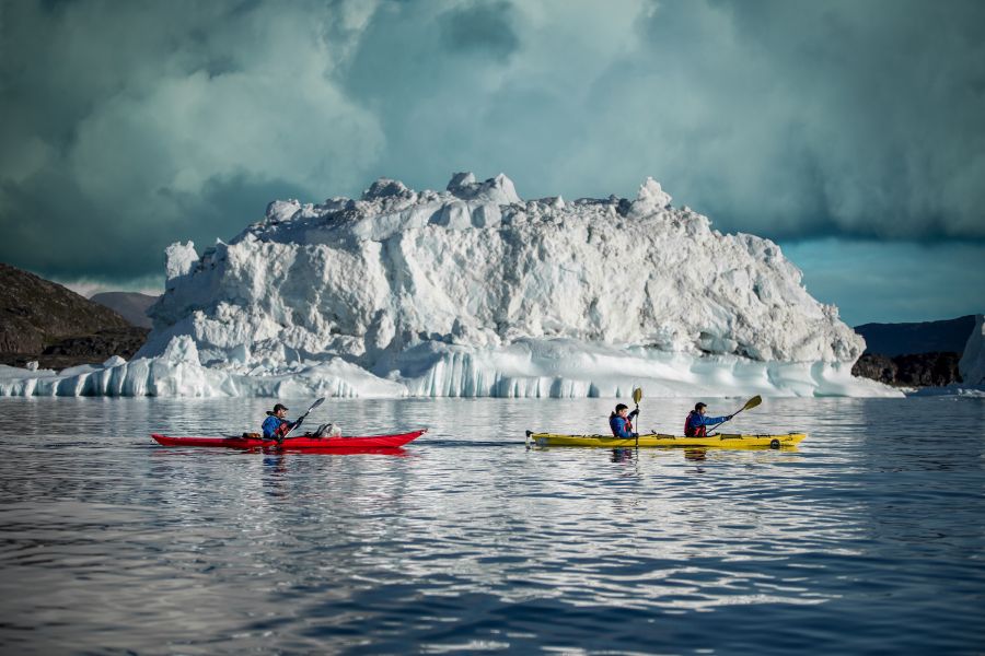 Two kayaks from PGI Greenland passing an iceberg in the Disko Bay near Oqaatsut in Greenland