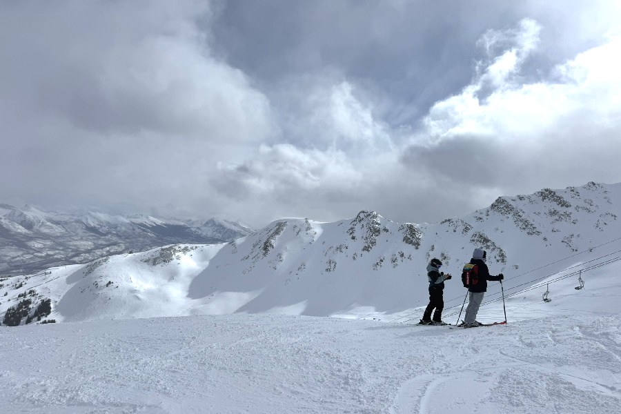 Twee skiers kijken uit over de omgeving van Marmot Basin