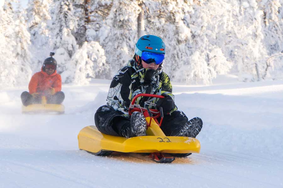 Rodelende jongen op de piste in de zon in Fulufjellet