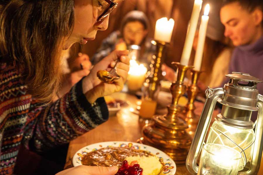 Vrouw met wildstoofpot in Stabburet in Vrådal