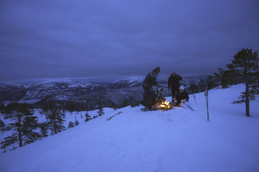 Mensen op de besneeuwde berg tijdens een sneeuwschoenwandeling in de avond