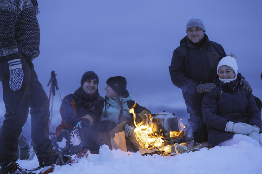 Mensen op de besneeuwde berg tijdens een sneeuwschoenwandeling in de avond