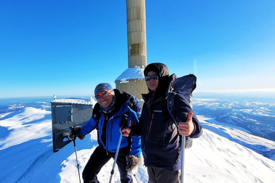 Twee mannen op de top van de besneeuwde berg