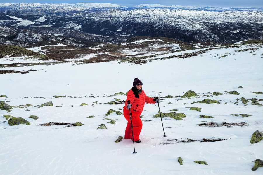 Vrouw die een sneeuwandeling doet op een besneeuwde berg