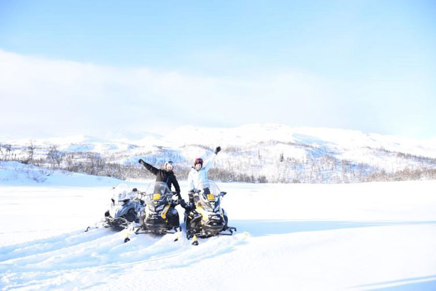 Mensen op een sneeuwscooter in de bergen