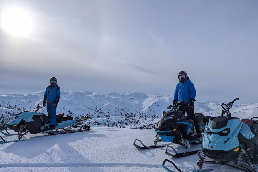 Mensen op een sneeuwscooter in de bergen